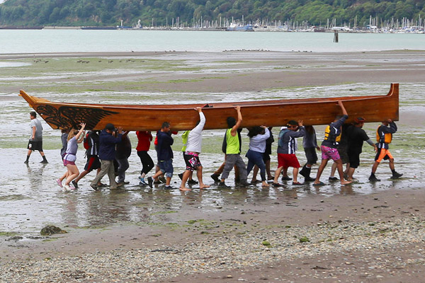 Tribal Canoue Journeys team carrying canoe